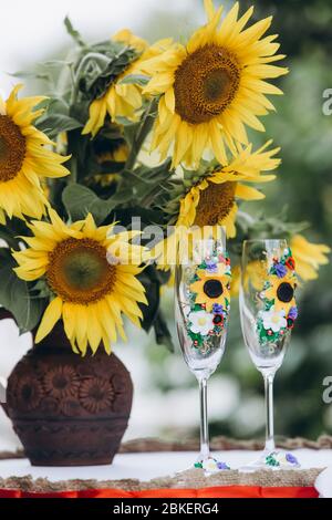 sunflowers in a vase next to champagne glasses Stock Photo