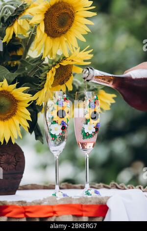 sunflowers in a vase next to champagne glasses Stock Photo