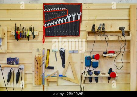 Tools hanging on the wall in a carpentry workshop. Wrenches, screwdrivers, pliers, coals, etc. Workshop scene Stock Photo
