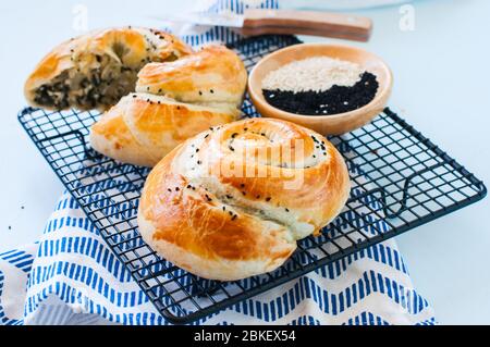 Freshly baked pie with spinach and cheese from flaky dough. Stock Photo