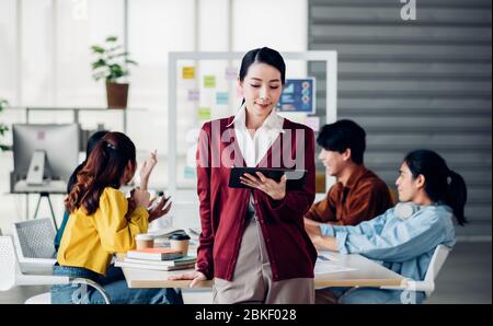 creative boss use tablet planning work while ux developer and ui designer brainstorm about mobile app interface design on whiteboard in meeting at mod Stock Photo