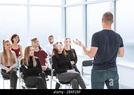 speaker makes a report for a group of diverse young people. Stock Photo