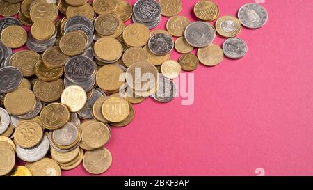 Top view of scattered coins from different countries on bright background. Concept of money financial saving. Stock Photo