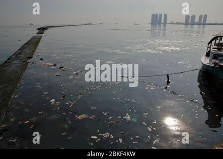 Marine pollution around breakwater structure at Muara Angke marina and fishing port in Penjaringan, North Jakarta, Indonesia. Stock Photo