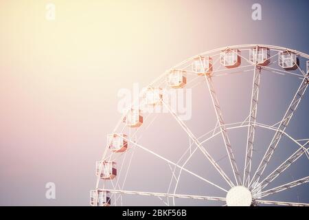 Vintage toned picture Ferris wheel amusement park. Vanilla sky at sunset Stock Photo