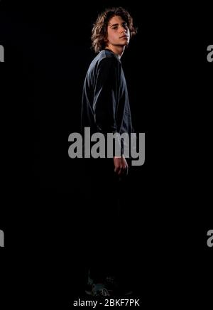 Attractive young male model posing in black pants and black sweater Stock Photo