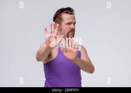 Young man with mustache coving away hands palms showing refusal and denial gesture with nervous and disgusting expression. Stop and forbidden. Stock Photo