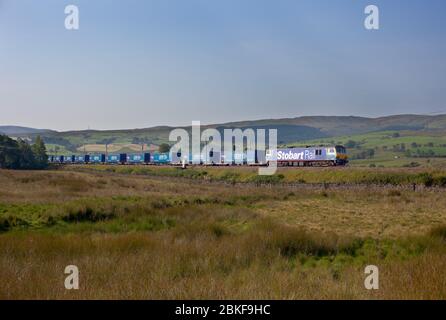 Stobart Rail livery class 92 electric locomotive hauling the Eddie Stobart / Tesco less co2 freight train on the west coast mainline in Cumbria Stock Photo