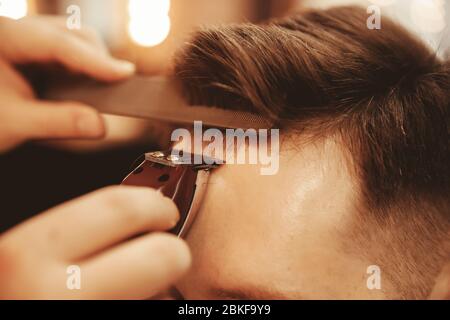 Alignment bangs on forehead of man close up in men Barber shop Stock Photo