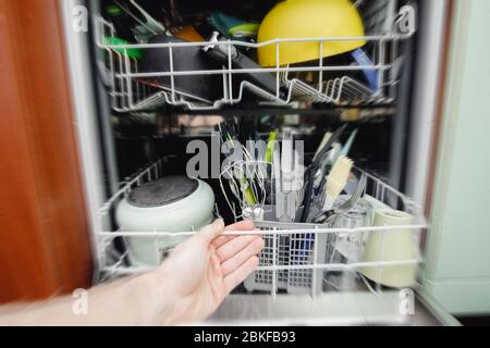 Open dishwasher dirty dishes set for washing with hand, effect moution blur. Concept water saving. Stock Photo