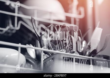 Open dishwasher with dirty dishes set for washing. Concept water saving. Stock Photo