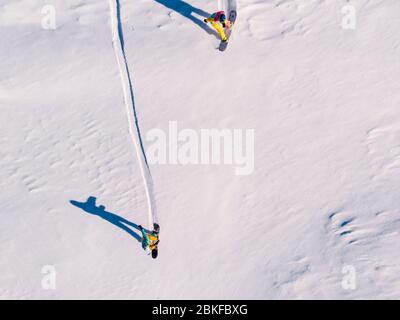 Athlete snowboarder rides off-piste clean snow snowboard, untouched in forest on slope. Aerial top view. Stock Photo