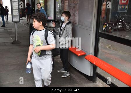Boys waiting at Bus stop during Lockdown Stock Photo