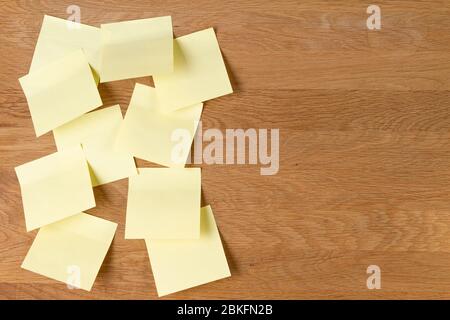 Sticky notes. Blank yellow square paper stickers on natural wooden board background Stock Photo