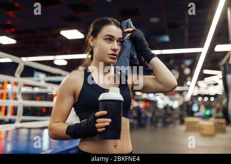 Tired woman wipes her sweat after boxing training Stock Photo