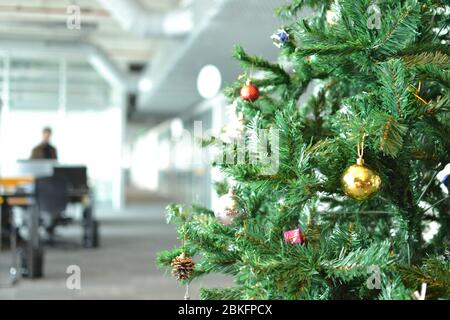 Christmas tree is decorated with lights and colorful ornaments in the office Stock Photo