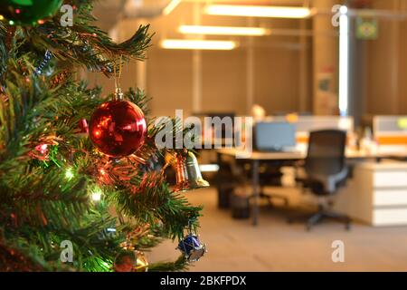 Christmas tree is decorated with lights and colorful ornaments in the office Stock Photo