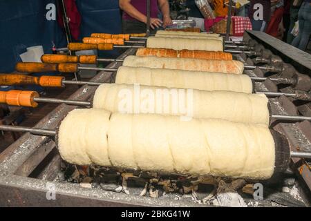 Kurtos kalacs or chimney cakes, preparing cooking on charcoal grill, street food traditional Hungarian, during food festival. Kurtos Kalacs traditiona Stock Photo