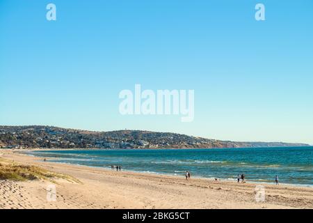 Adelaide, South Australia - December 22, 2018: People walking along Brighton beach coastline on a bright warm summer day Stock Photo