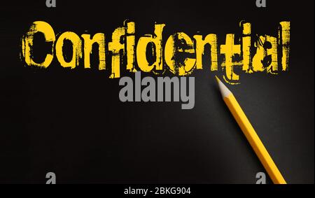 The word confidential yellow on black and a pencil besides. Secret personal or business data concept Stock Photo