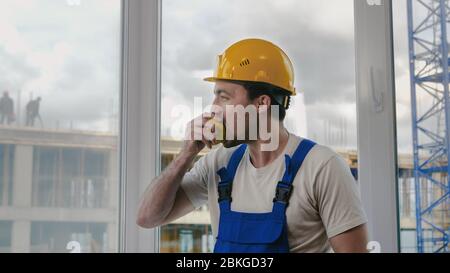 Construction worker having a break and eating apple. Stock Photo