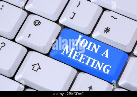 A keyboard with words JOIN A MEETING in white lettering on a blue enter key. Apps for video call conferencing concept. England, UK, Britain Stock Photo