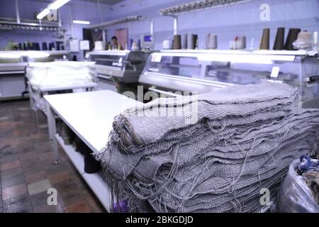 Pink spools of thread on the background of the sewing workshop. Clothing industry. Machine for the textile industry. Manufacture of wearing apparel Stock Photo