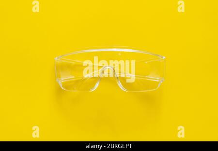 Protective glasses lying on a yellow background. Stock Photo