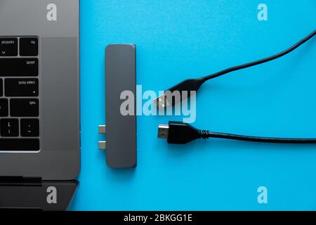 Laptop with USB Type-C adapter with unpluged USB cables. The USB adapter under the Type-C connector for laptop. Multiport station for laptop with Stock Photo