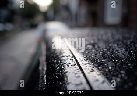 Selective focus on rain drops on top of a black car Stock Photo