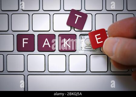 PHOTOMONTAGE, computer keys labeled Fake, symbol photo for Fake News  /  FOTOMONTAGE, Computertasten mit der Aufschrift Fake, Symbolfoto für Fake News Stock Photo