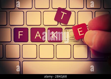 PHOTOMONTAGE, computer keys labeled Fake, symbol photo for Fake News  /  FOTOMONTAGE, Computertasten mit der Aufschrift Fake, Symbolfoto für Fake News Stock Photo