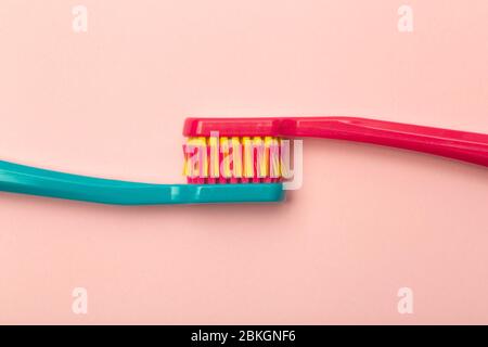 Toothbrushes of different colors on a pink background. Brushing teeth and oral hygiene. Stock Photo