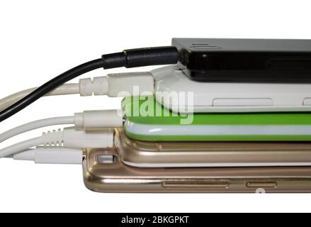 Stack of charging mobile phones, isolated on white background Stock Photo
