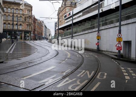 Empty tram lines looking up Corporation Street with what is affectionately known the ramp on the right in Birmingham city centre, which is virtually deserted under Coronavirus lockdown on a wet rainy afternoon on 28th April 2020 in Birmingham, England, United Kingdom. Britains second city has been in a state of redevelopment for some years now, but with many outdated architectural remnants still remaining, on a grey day, the urban landscape appears as if frozen in time. Coronavirus or Covid-19 is a new respiratory illness that has not previously been seen in humans. While much or Europe has be Stock Photo