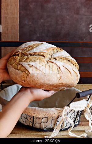Homemade Freshly Baked Country Bread  in a basket made from wheat and whole grain flour. French Freshly baked bread in children's hands. Slicing homem Stock Photo