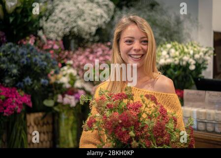 Young woman standing in flower shop Stock Photo