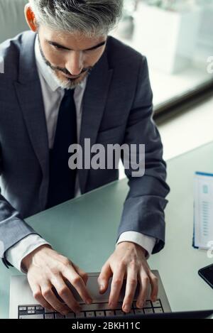 Businessman using laptop in office Stock Photo