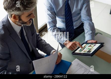 Businessmen discussing over digital tablet Stock Photo