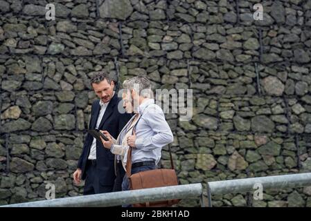 Businesspeople using digital tablet in public park Stock Photo