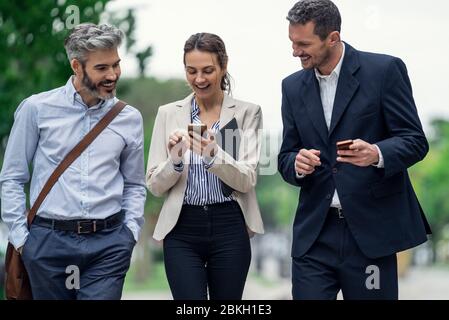 Business people using smartphones in public park Stock Photo