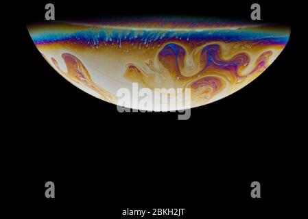 Imitation of an unknown planet. High resolution. Half a soap bubble. Close-up. Black background. Bright colors. Side view. The theme of science fictio Stock Photo
