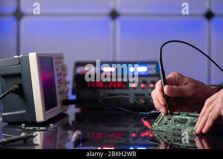 Debugging electronics device. PCB witch microcontroller in electronics laboratory Stock Photo
