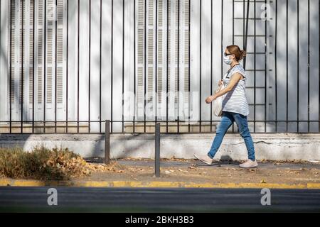 One pregnant woman worried and walking in Providencia streets during coronavirus disease infection COVID-19 with distance and mask protection Stock Photo