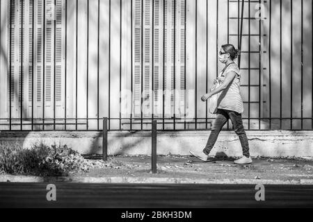 One pregnant woman worried and walking in Providencia streets during coronavirus disease infection COVID-19 with distance and mask protection Stock Photo