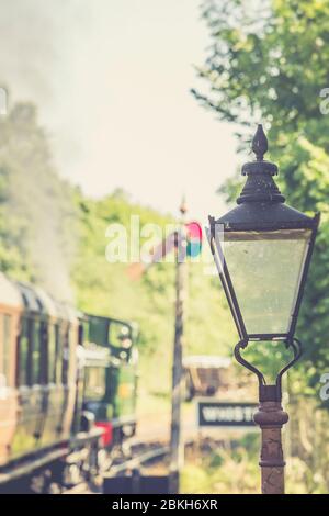 Retro, vintage view of old fashioned, traditional gas lamp as UK steam train is leaving Highley station, Severn Valley Railway heritage line, 1940s UK. Stock Photo