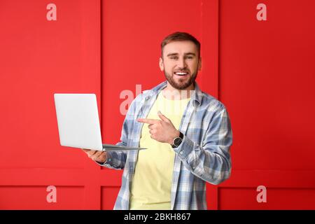 Male programmer with laptop on color background Stock Photo