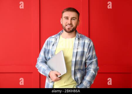 Male programmer with laptop on color background Stock Photo