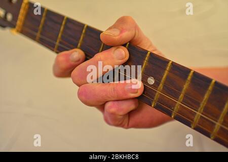 Man hand playing on acoustic guitar. Close-up. Hand of man playing the old acoustic guitar. Stock Photo