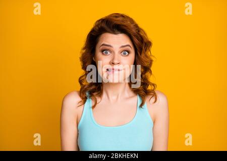 Oops. Closeup photo of girlish shocked foxy lady big eyes funny facial expression biting lips tricky person wear teal casual singlet isolated bright Stock Photo